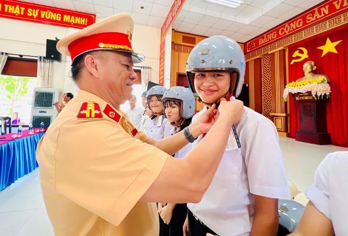 Đại tá Phan Thanh Hồng - Trưởng Phòng Cảnh sát giao thông (CSGT) Công an thành phố Đà Nẵng trao tặng những phần quà là mũ bảo hiểm cho người tham gia trả lời đúng các câu hỏi của Ban tổ chức.