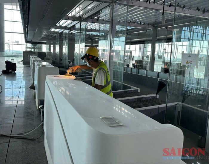  Công nhân chà nhám, đánh bóng các quầy xử lý thủ tục tại khu vực nhà ga hành khách 