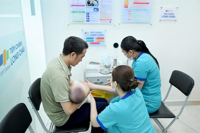 Phụ huynh đưa trẻ tiêm vaccine não mô cầu tại một cơ sở tiêm chủng trên địa bàn TPHCM