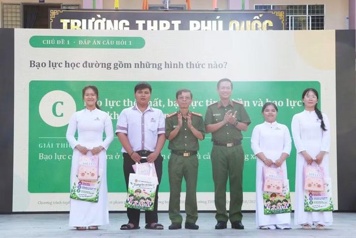  Đại tá Nguyễn Nhật Trường, Phó Giám đốc Công an tỉnh An Giang và Đại tá Nguyễn Chí Nguyện, Trưởng phòng Cảnh sát hình sự, trao quà cho các em học sinh. 