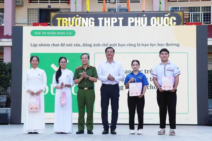 Thiếu tướng Phan Mạnh Trường, Phó Cục trưởng Cục Cảnh sát hình sự và ông Huỳnh Văn Hoá, Phó Giám đốc Sở Giáo dục và Đào tạo tỉnh An Giang, trao quà cho các em học sinh.