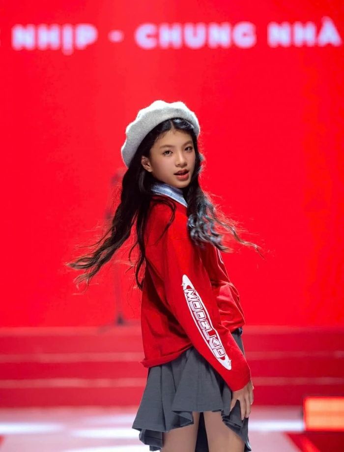 Xuất hiện tại Chung kết Model Kid Việt Nam, mẫu nhí lựa chọn chiếc sweater màu đỏ kết hợp chân váy xám, mũ nồi trắng và giày thể thao. (Ảnh: Tú Uyên)