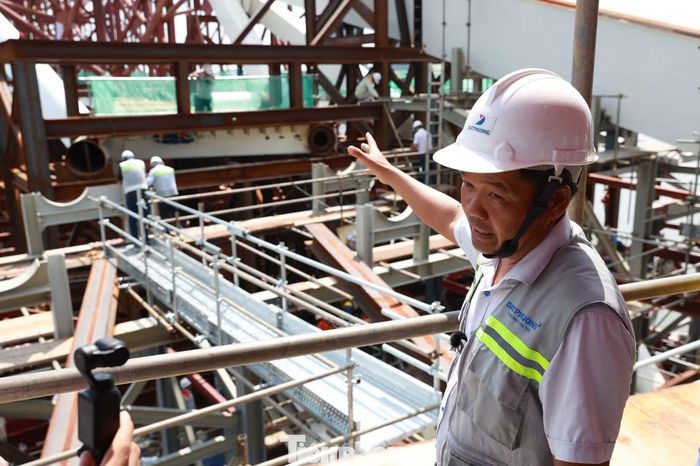 Ông Nguyễn Thanh Nhân - Phó ban điều hành thuộc nhà thầu Đạt Phương - cho biết: “Sau khi sà lan được định vị, chúng tôi tiến hành căn chỉnh cao độ giữa nhịp vòm thép lai dắt từ Vũng Tàu và phần kết cấu đã thi công tại công trường. Thời điểm ghi nhận, đầu dầm thép trên sà lan còn cao hơn phần kết cấu phía công trường hơn 10 cm. Để đưa hai phần về cùng cao độ, chúng tôi điều chỉnh lượng nước dằn, kết hợp hệ thống kích thủy lực để thay đổi độ chìm của sà lan. Khi hai đầu dầm nằm trên cùng mặt phẳng, các kỹ sư tiếp tục căn chỉnh chính xác vị trí, lắp bu lông và liên kết các cấu kiện, bảo đảm yêu cầu kỹ thuật trong quá trình hợp long”.