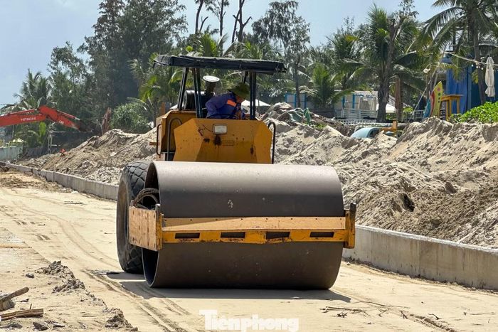 Công nhân khẩn trương hoàn thiện tường chắn, lu nền đường.