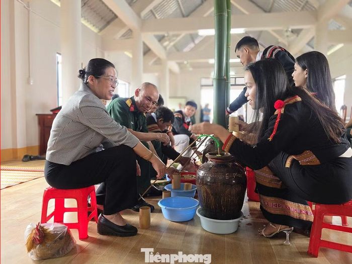 Các đại biểu thực hiện nghi thức uống rượu cần giao lưu.
