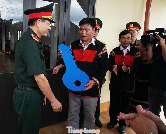 Đại tá Nguyễn Văn Oanh, Phó Cục trưởng Cục Dân vận, Tổng cục Chính trị Quân đội nhân dân Việt Nam thực hiện nghi lễ trao chìa khóa công trình cho đại diện buôn Kđoh.