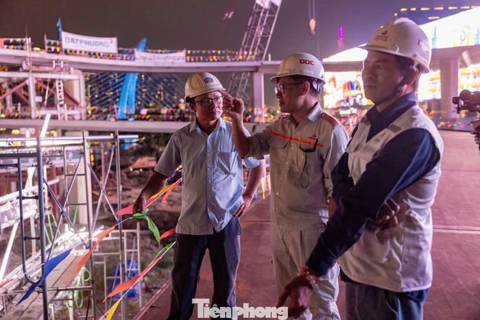 Các kỹ sư, công nhân theo dõi quá trình rút sà lan khỏi công trường vào tối 21/10, khép lại một công đoạn thi công căng thẳng kéo dài nhiều giờ liền.
