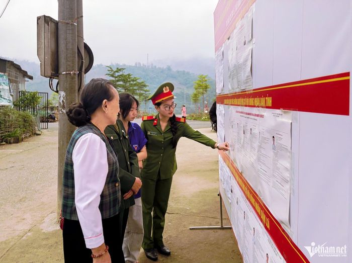 Thiếu úy Nhị hướng dẫn người dân tìm hiểu về bầu cử đại biểu Quốc hội khóa XVI và đại biểu HĐND các cấp nhiệm kỳ 2026 - 2031 tại bản Bo, xã Bum Tở