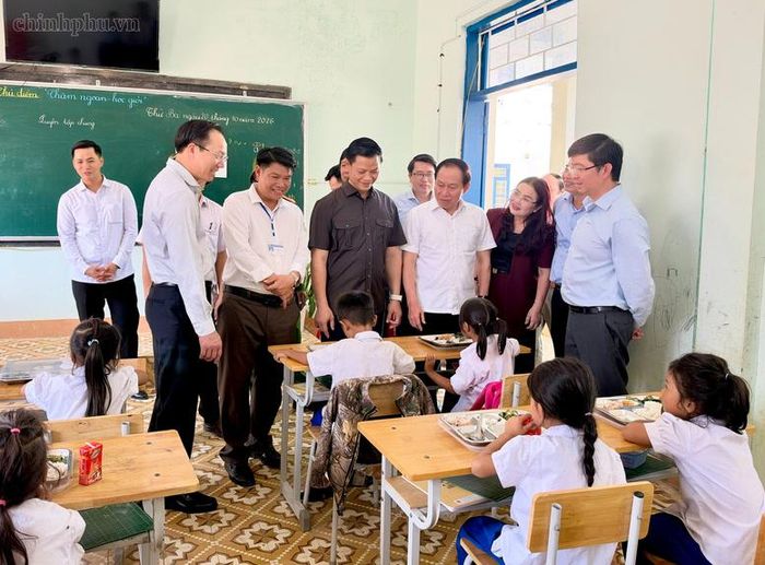 Phó Thủ tướng Lê Tiến Châu trò chuyện với các em học sinh đang ăn trưa tại trường. Ảnh: Chinhphu.vn