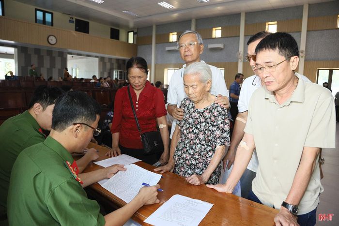 Ông Nguyễn Trọng Thịnh (ngoài cùng bên phải) thực hiện các bước theo hướng dẫn để hoàn tất thủ tục thu nhận mẫu ADN.