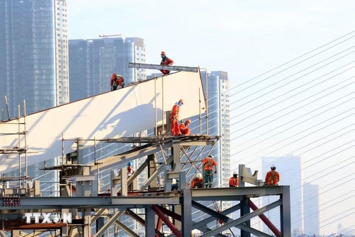 Các kỹ sư, công nhân làm việc trên công trường, chuẩn bị cho quá trình hợp long dự án cầu đi bộ qua sông Sài Gòn. (Ảnh: Tiến Lực/TTXVN)