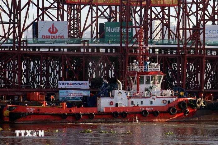 Quá trình căn chỉnh, hạ tải được hỗ trợ bằng hệ thống kích thủy lực và xe tự hành đa trục SPMT, kết hợp bơm nước dằn vào sà lan để tăng trọng lượng. (Ảnh: Tiến Lực/TTXVN)