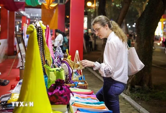 Du khách nước ngoài xem các sản phẩm tại gian trưng bày của làng lụa Vạn Phúc. (Ảnh: Khánh Hòa/TTXVN)