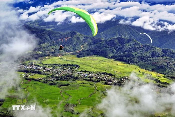Khách du lịch trải nghiệm bay dù lượn tại bản du lịch cộng đồng Sì Thâu Chải (Lai Châu). Ảnh: TTXVN phát