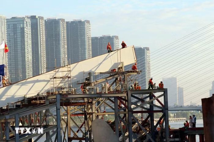 Các kỹ sư, công nhân làm việc trên công trường, chuẩn bị cho quá trình hợp long dự án cầu đi bộ qua sông Sài Gòn. (Ảnh: Tiến Lực/TTXVN)
