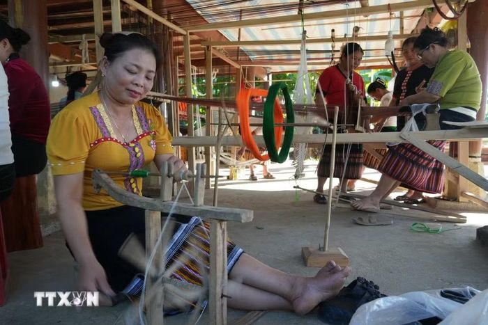 Nhiều bà, nhiều mẹ ở bản bãi Gạo, xã Châu Khê, miệt mài từng khâu chuẩn bị sợi, lên khung đến đưa thoi, tạo hoa văn. (Ảnh: Bích Huệ/TTXVN)