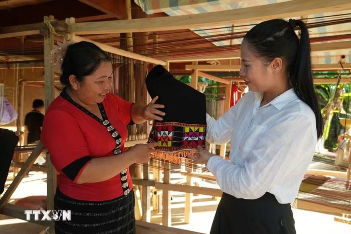 Không chỉ học cách làm ra sản phẩm, chị em còn hiểu thêm ý nghĩa của những họa tiết gắn với đời sống văn hóa người Thái. (Ảnh: Bích Huệ/TTXVN)