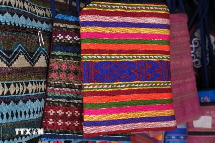 Từ trang phục truyền thống, các sản phẩm như khăn quàng, túi vải, ví nhỏ, bìa sổ và đồ lưu niệm được đồng bào người Thái làm phong phú hơn, vừa giữ nét hoa văn đặc trưng, vừa đáp ứng nhu cầu của khách hàng. (Ảnh: Bích Huệ/TTXVN)