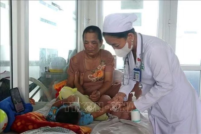 Bác sĩ kiểm tra các triệu chứng trên cơ thể của một bệnh nhi đang điều trị bệnh tay chân miệng.
