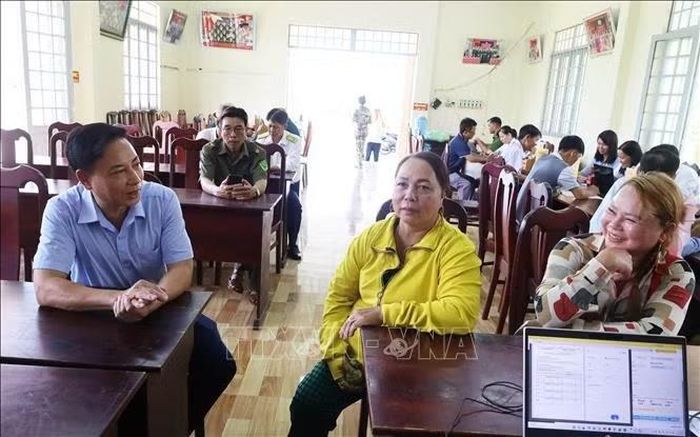 Chủ tịch UBND phường Đồng Phú Hồ Hùng Phi (đầu tiên, trái sang) trao đổi, nắm bắt tình hình giải quyết thủ tục hành chính, hướng dẫn người dân thực hiện hồ sơ tại điểm phục vụ dịch vụ công lưu động.