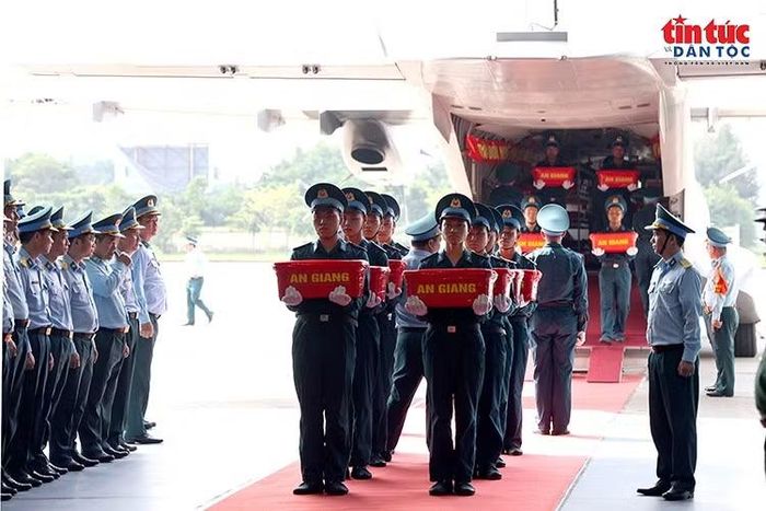 Cán bộ, chiến sĩ Không quân đưa các thùng chứa mẫu sinh phẩm hài cốt liệt sĩ xuống máy bay tại sân bay Gia Lâm.
