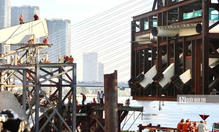 Công nhân làm việc bất kể ngày đêm trên các sàn đà giáo hệ khung treo để kiểm tra từng thông số kỹ thuật mố neo trụ. Hệ mố cầu siêu khủng đúc sẵn sát mép nước chuẩn bị làm điểm tựa vững chắc để tiếp nhận kết cấu nhịp vòm thép hình lá dừa.