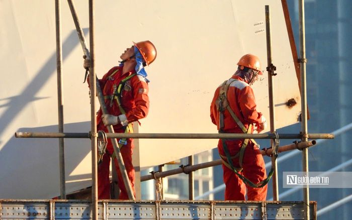 Các kỹ sư, công nhân miệt mài làm việc trên công trình cầu đi bộ bắc qua sông Sài Gòn.