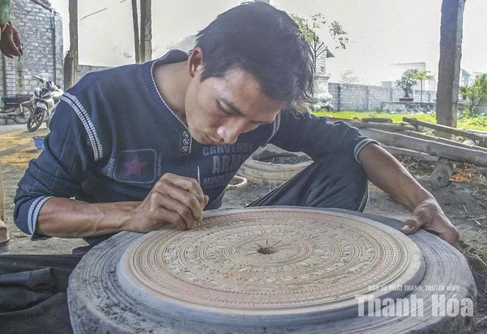 Người thợ ở làng nghề đúc đồng Trà Đông (xã Thiệu Trung) làm thủ công những đường nét hoa văn tinh xảo trên bề mặt khuôn đúc trống đồng.