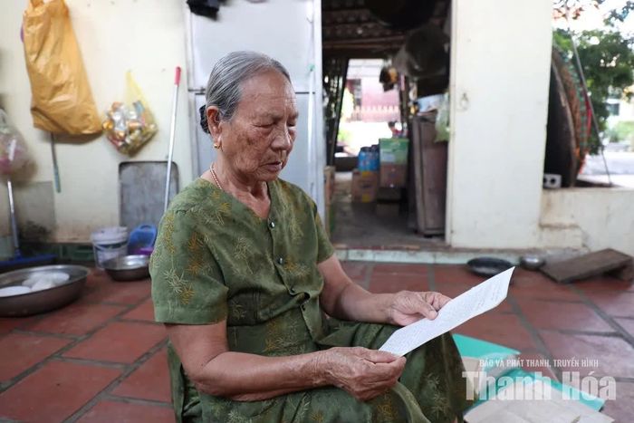 Bà Nguyễn Thị Ứng xem lại những trang viết tay được lưu giữ tại nhà riêng.