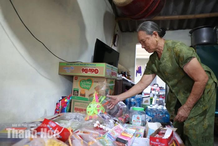 Bà Nguyễn Thị Ứng sắp xếp hàng hóa trong gian hàng nhỏ đã gắn bó với bà hơn 20 năm.