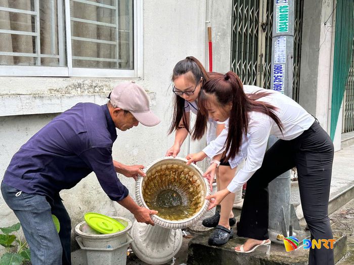 Cán bộ Trạm Y tế phường Cẩm Lệ cùng người dân kiểm tra, loại bỏ các ổ lăng quăng. Ảnh: TRÂM ANH