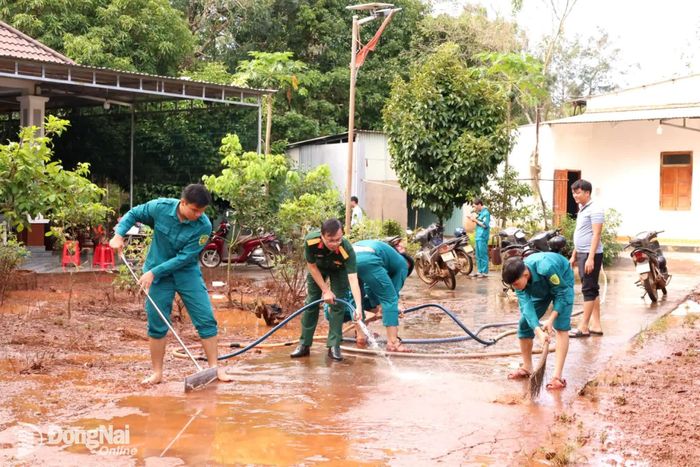 Lực lượng chức năng xã Long Hà hỗ trợ người dân dọn vệ sinh sau ngập. Ảnh: Phạm Yến