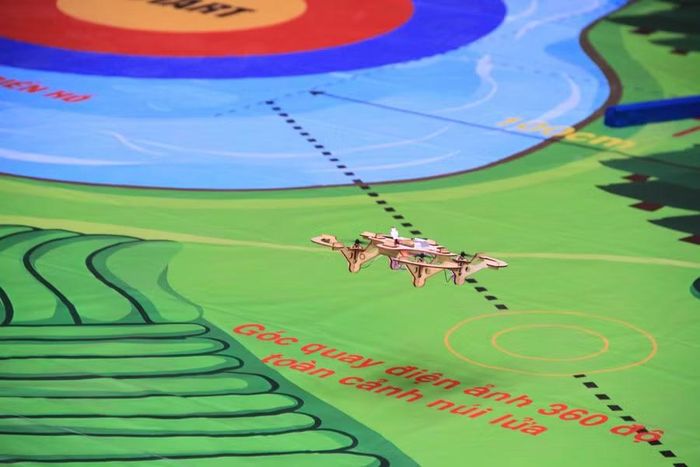  Drone di chuyển trên sa bàn mô phỏng địa hình, thực hiện nhiệm vụ điều hướng theo lộ trình được thiết kế. Các cổng bay mô phỏng rừng thông trăm tuổi, đồi chè Tây Gia Lai và khe núi lửa Chư Đang Ya, với yêu cầu cụ thể về độ cao, hướng bay và góc nghiêng của thiết bị. Ảnh: Hoàng Hoài 