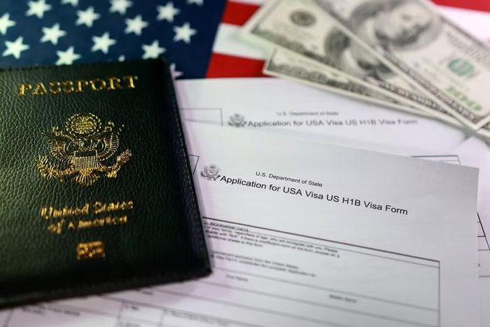 Mẫu đơn xin visa H-1B cùng một hộ chiếu Mỹ trong ảnh chụp tháng 9-2025. Ảnh: Reuters