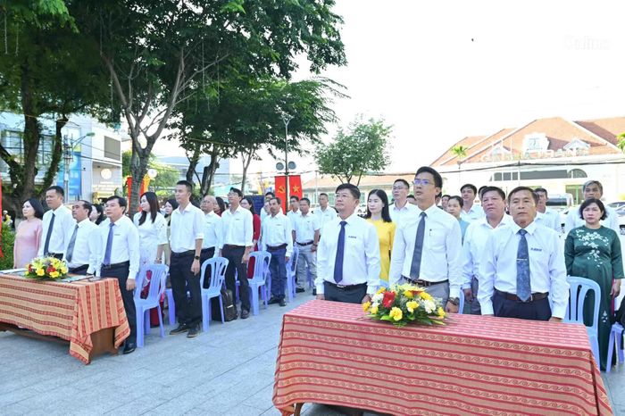 Các đại biểu, đảng viên, quần chúng ưu tú thực hiện nghi thức chào cờ.