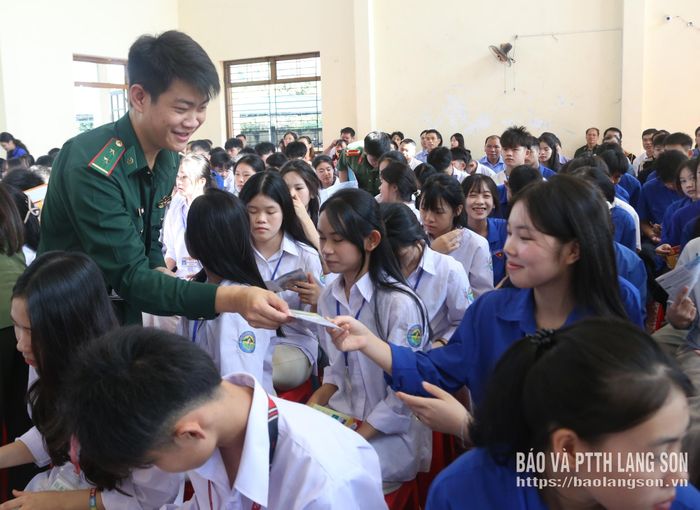 Cán bộ biên phòng phát tờ rơi tuyên truyền pháp luật cho học sinh