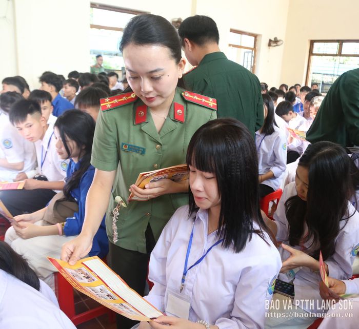 Cán bộ Phòng Quản lý xuất nhập cảnh, Công an tỉnh phát tờ rơi tuyên truyền pháp luật cho học sinh