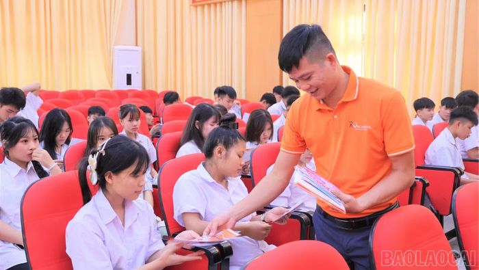 Đại diện các doanh nghiệp phát tờ rơi giới thiệu việc làm cho người lao động.