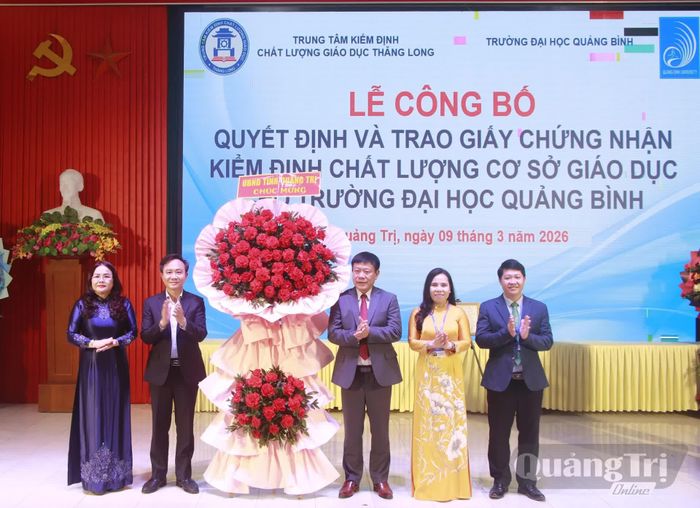 Đồng chí Hoàng Xuân Tân, Phó Chủ tịch UBND tỉnh và lãnh đạo Sở Giáo dục-Đào tạo tặng hoa chúc mừng Trường đại học Quảng Bình được công nhận đạt chuẩn kiểm định chất lượng cơ sở giáo dục - Ảnh: ĐHQB