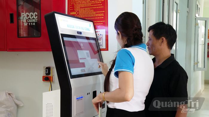 Hội viên phụ nữ xã Cửa Tùng hướng dẫn người dân thực hiện thủ tục hành chính trực tuyến qua Kiosk Dịch vụ công tại Trung tâm Phục vụ hành chính công xã - Ảnh: P.Q