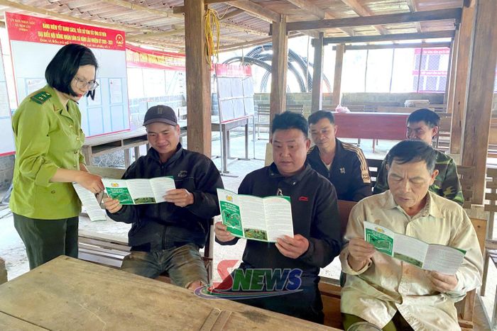 Cán bộ Ban quản lý rừng đặc dụng phòng hộ Thuận Châu phát tờ rơi tuyên truyền cho người dân.
