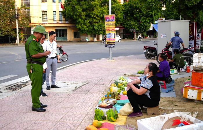 Lực lượng chức năng nhắc nhở người dân bán hàng, họp chợ không đúng nơi quy định tại khu vực ngã tư Nguyễn Thị Minh Khai, phường Đức Xuân.