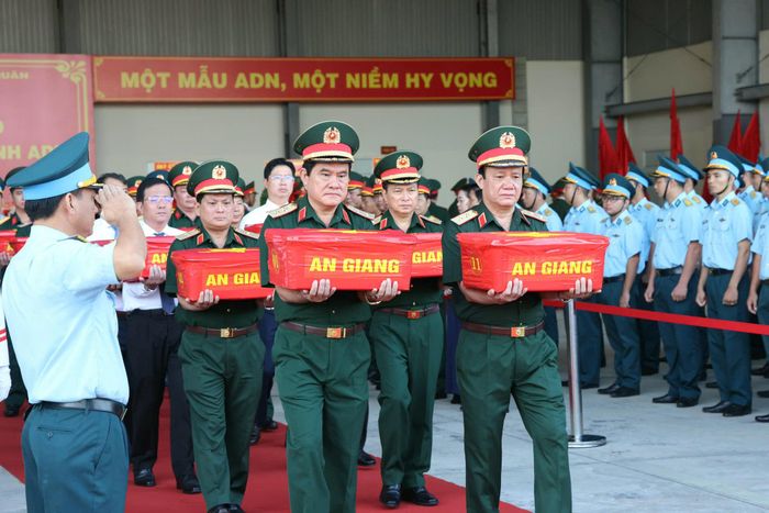 Các đại biểu đưa các mẫu sinh phẩm hài cốt liệt sĩ lên máy bay quân sự vận chuyển về Hà Nội. Ảnh: Phạm Trung