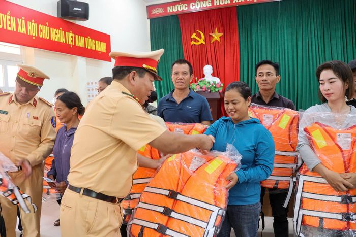 Lực lượng chức năng trao tặng áo phao cứu sinh cho người dân vạn chài.