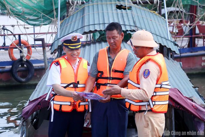 Cảnh sát đường thủy phát hàng trăm tờ rơi cho người dân vạn chài.