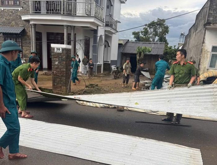 Lực lượng chức năng hỗ trợ nhân dân sửa chữa nhà.