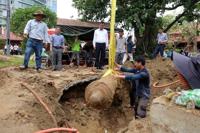 Ông Lê Ngọc Quang (áo trắng) trực tiếp kiểm tra việc đưa khẩu súng thần công lên mặt đất.