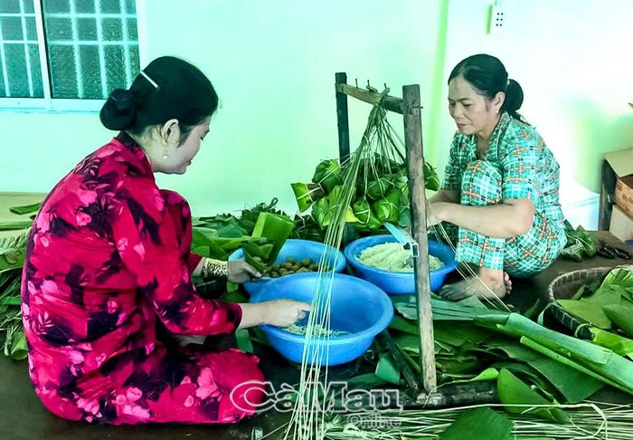 Bà Trần Thuý Sang (bên phải) hướng dẫn con cháu kỹ thuật gói bánh ú nếp tro, tiếp nối nghề truyền thống của gia đình.