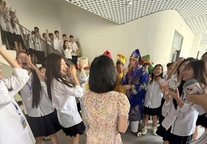 Nhiều học sinh đứng quanh nhóm hóa trang, cười vui và dùng điện thoại lưu lại khoảnh khắc.