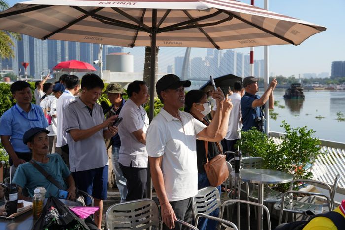 Người dân tập trung ở Bến Bạch Đằng, ghi lại hình ảnh công tác hợp long sáng 21/10. 